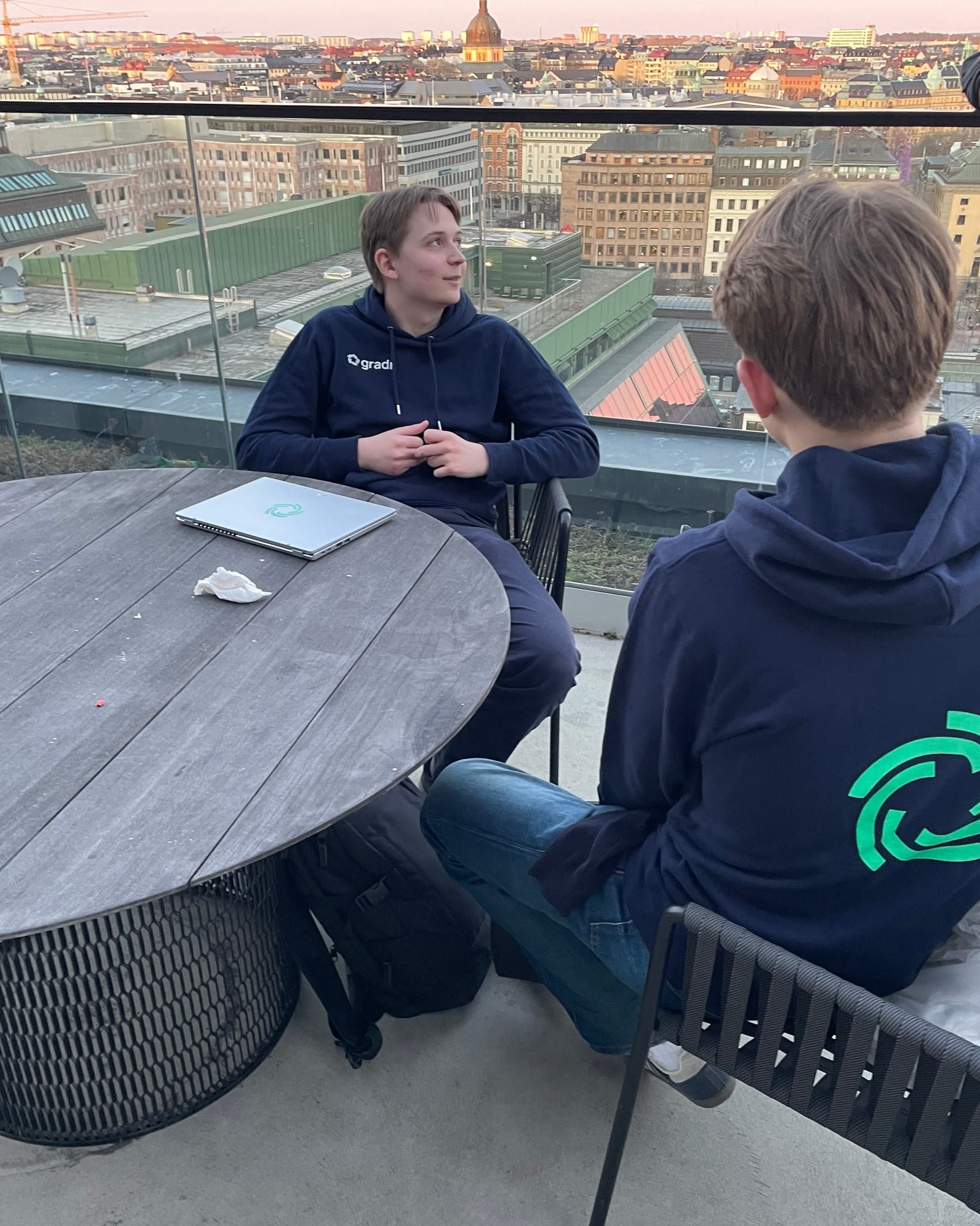 Två från teamet vid ett bord på en takterrass i Stockholm